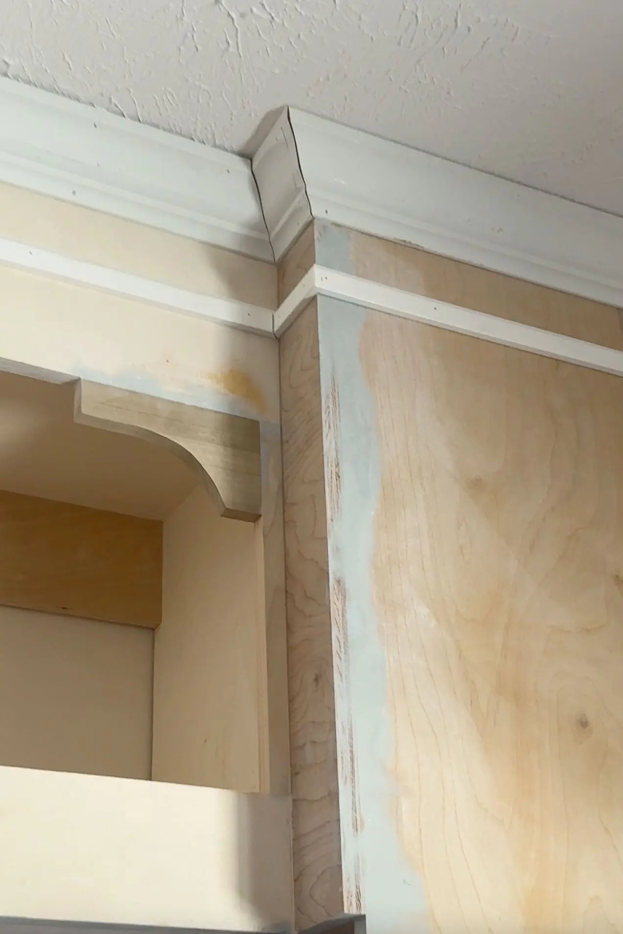 Close-up of crown molding and trim detail on a custom-built headboard with storage for a nursery.